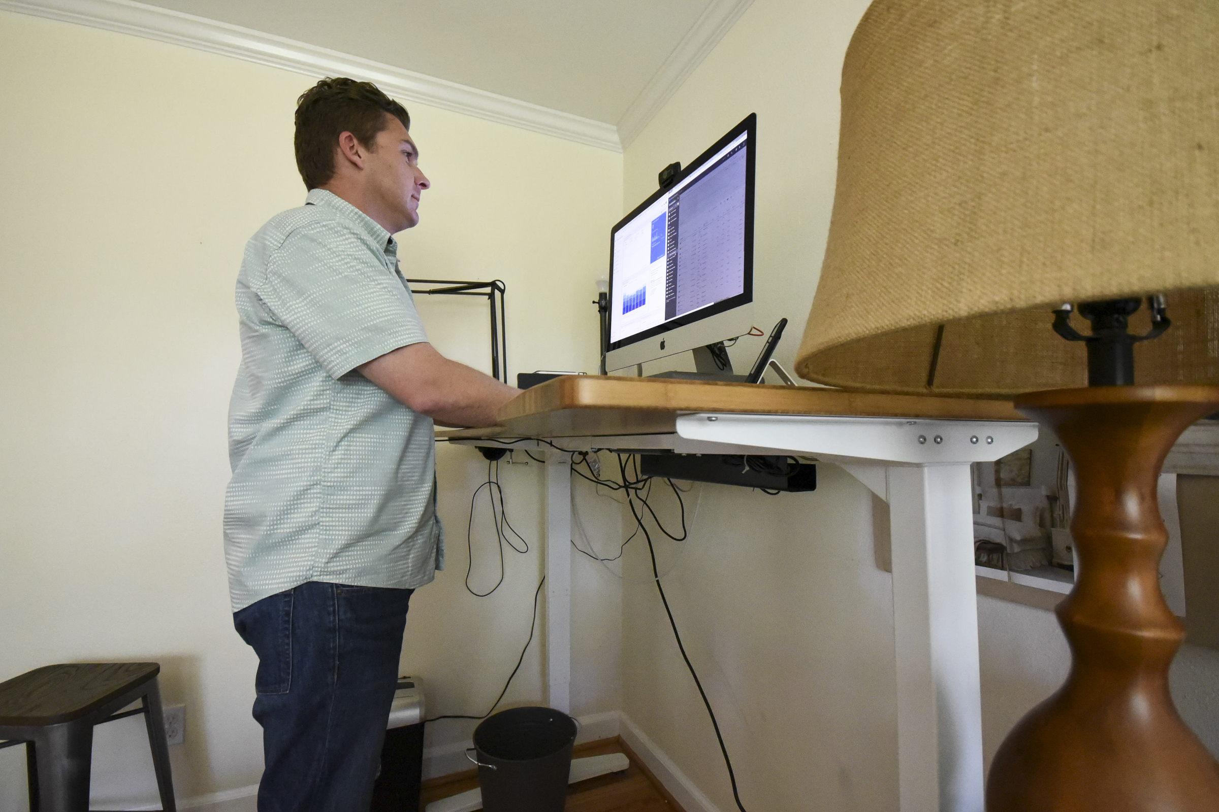 Rob Bettis stands at his desk and performs his marketing work from home in Stuart Heights.