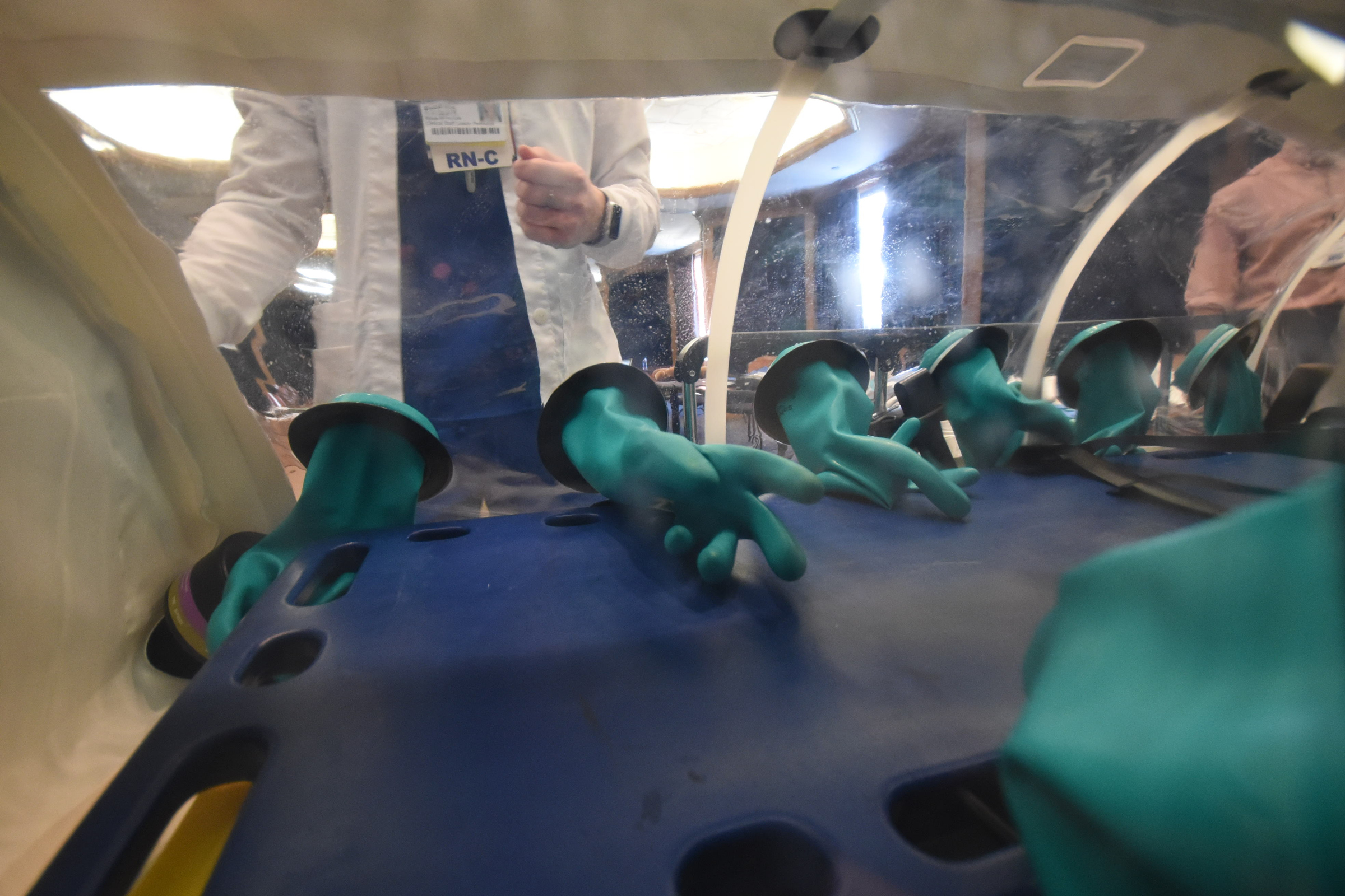 The identity badge of Suzanne Hornsby, team lead for special pathogens at Erlanger, is seen through the patient isolation transport unit in the event of an unidentified infectious outbreak.