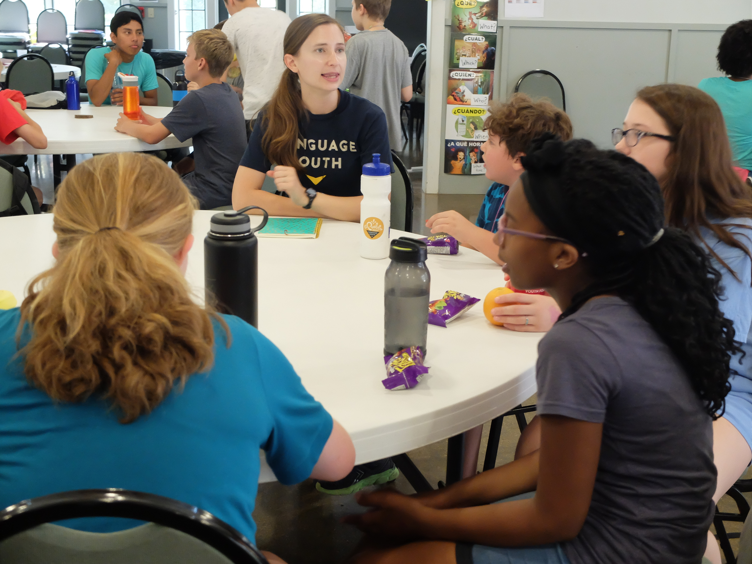 Emily Valdes talks with a group of campers during a snack break Friday at Booker T. Washington State Park. The camp is known as the El Pueblo Spanish Camp.