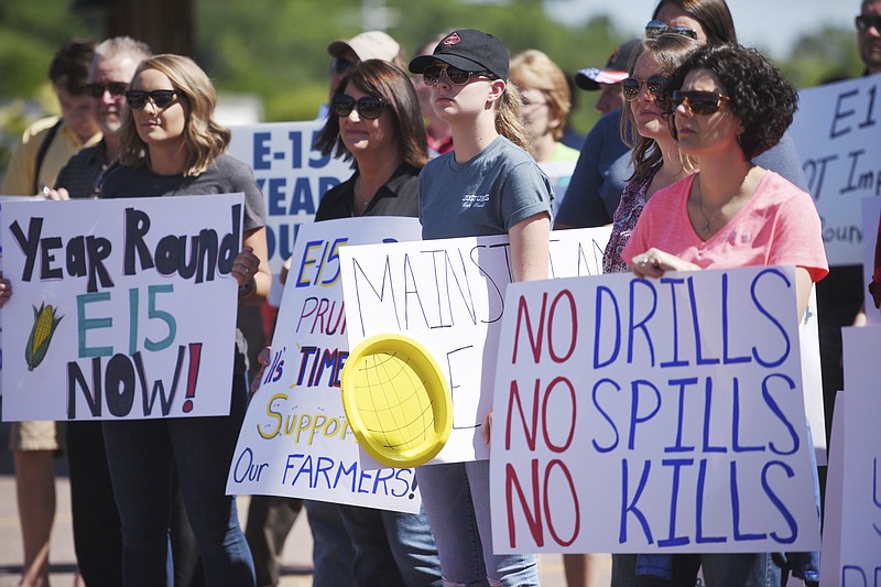Farmers and supporters hold signs in Falls Park to support the ethanol industry in response to Scott Pruitt, Trump's EPA administrator, touring South Dakota, Wednesday, June 13, 2018, in Sioux Falls, S.D. (Briana Sanchez/The Argus Leader via AP)

