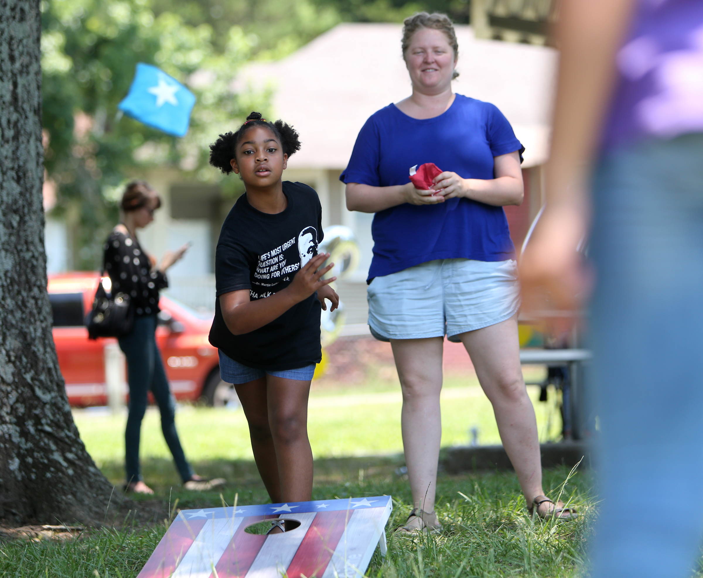 Lauren Hambrick, 10, plays corn hole during at Tech Goes Home celebration as Mary Stargel looks on Sunday, June 17, 2018 at East Lake Park in Chattanooga, Tennessee. Tech Goes Home, which offers program for adults and children, celebrated a milestone of 3,000 graduates Sunday.