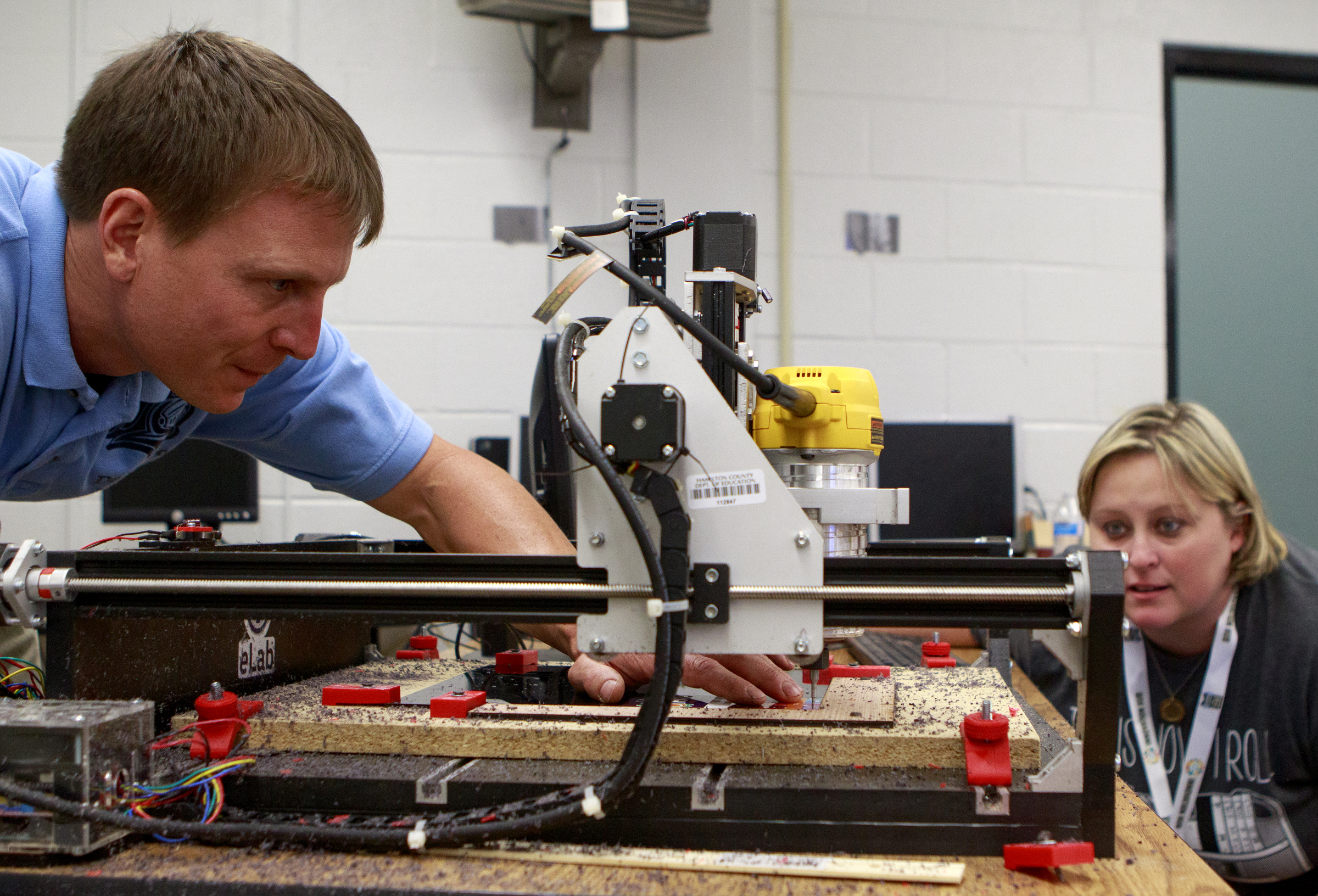 Dalewood Volkswagen eLab Specialist Chris Seanard, left, helps Hixson High School Librarian Lindsey McCarter prepare to carver her name for her clock back as part of the design challenge for the Chattanooga Fabrication Institute at Dalewood Middle School on Monday, June 18, 2018 in Chattanooga, Tenn.