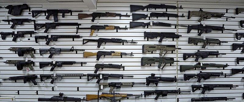 FILE - This Nov. 7, 2017, file photo shows dozens of semi-automatic rifles on a wall in a gun shop in Lynnwood, Wash. 