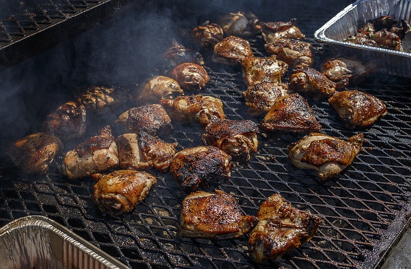 Barbecue chicken cooks on a grill at the 2017 Ooltewah Barbecue Brawl at Cambridge Square. This year's contest on Saturday will pit eight local barbecue teams in people's choice and judges' contest. (Staff File Photo by Doug Strickland)