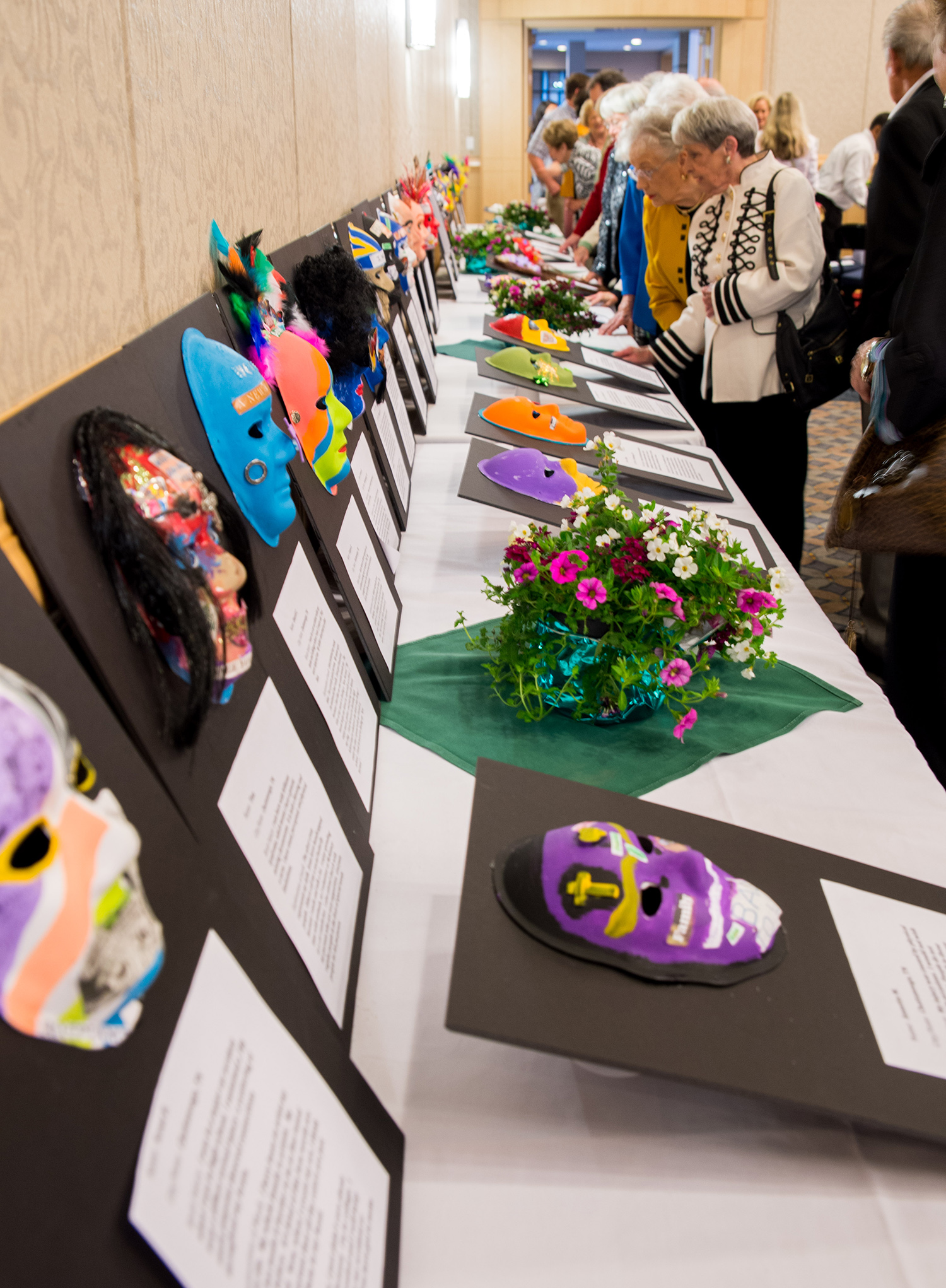 Attendees check out masks made for the fundraising luncheon.