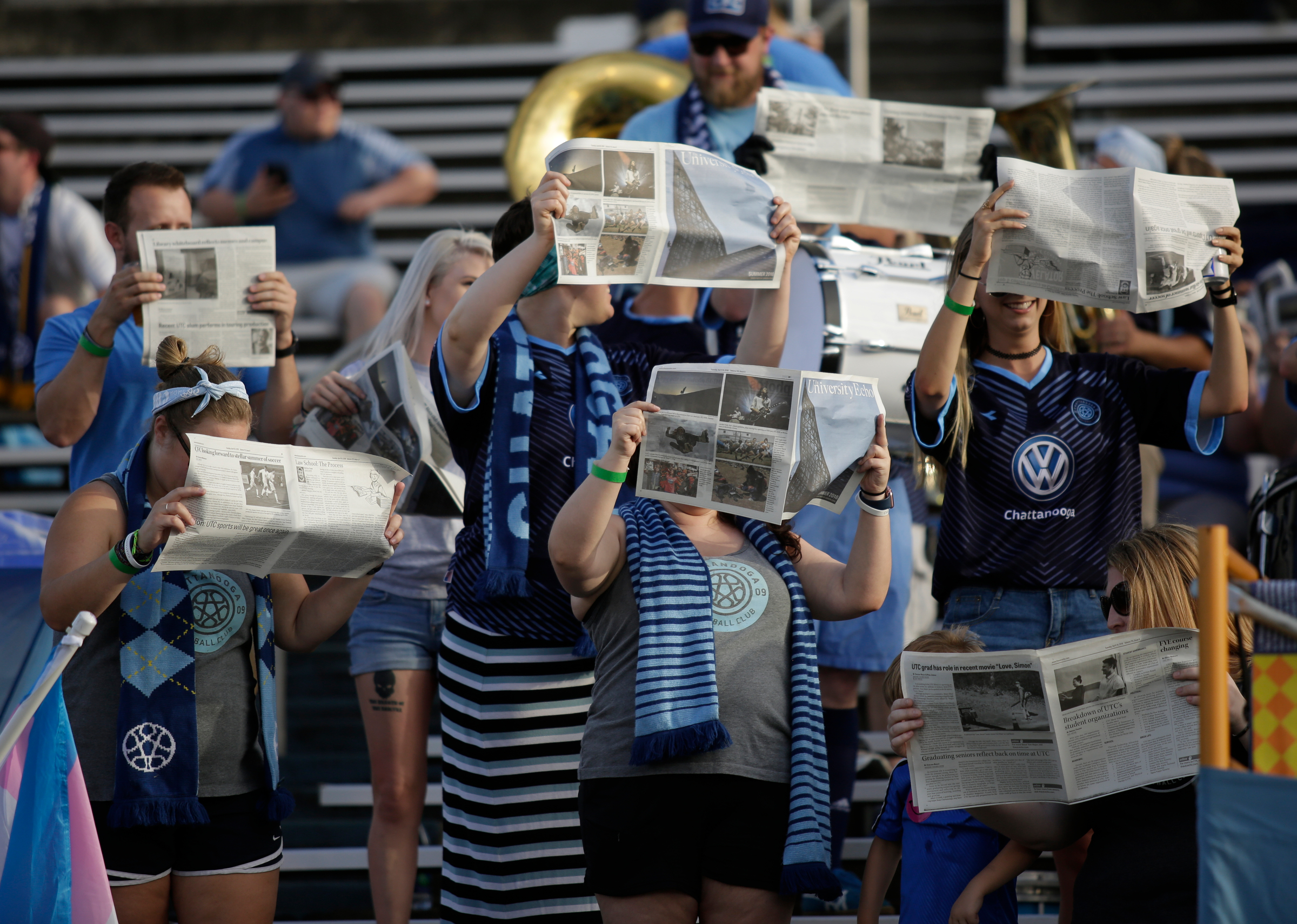 Chattahooligans hold up copies of the UTC Echo newspaper as the opposing team takes the field for Chattanooga FC's soccer match against the Atlanta Silverbacks at Finley Stadium on Wednesday, June 20, 2018, in Chattanooga, Tenn.