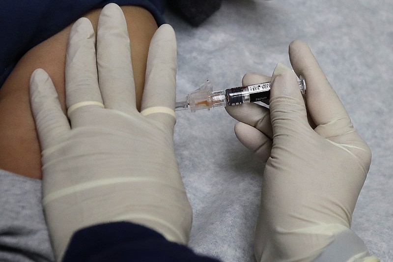 In this Jan. 12, 2018, file photo, a medical assistant at a community health center gives a patient a flu shot in Seattle. A newer kind of flu vaccine worked a little bit better in seniors this past winter than traditional shots, the government reported Wednesday, June 20, 2018. (AP Photo/Ted S. Warren, File)