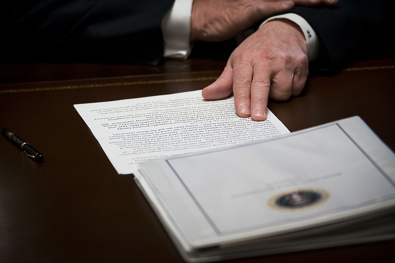 President Donald Trump looks over notes as he speaks during a Cabinet meeting, in the Cabinet Room of the White House, in Washington. Earlier Thursday, Trump returned to his tough talk and called for changes in immigration laws a day after he retreated from his hard-line position of separating immigrant children from their families, capitulating to intense political pressure. (Doug Mills/The New York Times)
