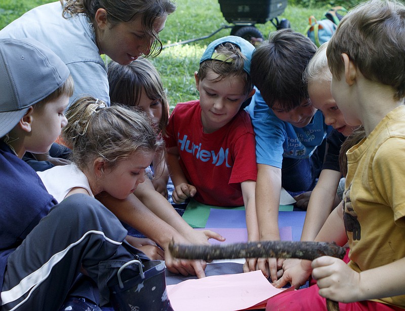 Counselor Rosie Garber, top left, helps campers learn their colors in German during an immersion camp, part of the Wauhatchie's Forest School School Summer Camp, at Reflection Riding Arboretum and Nature Center on Friday, June 22, 2018 in Chattanooga, Tenn.