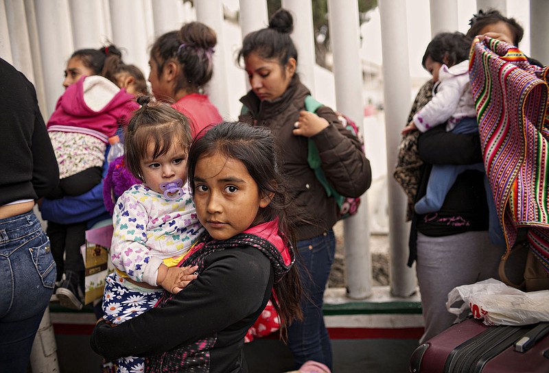 Undocumented migrants wait for asylum hearings outside the port of entry in Tijuana, Mexico, on Wednesday. President Donald Trump caved to enormous political pressure on Wednesday and signed an executive order that ends the separation of families by indefinitely detaining parents and children together at the border. (Sandy Huffaker/The New York Times)