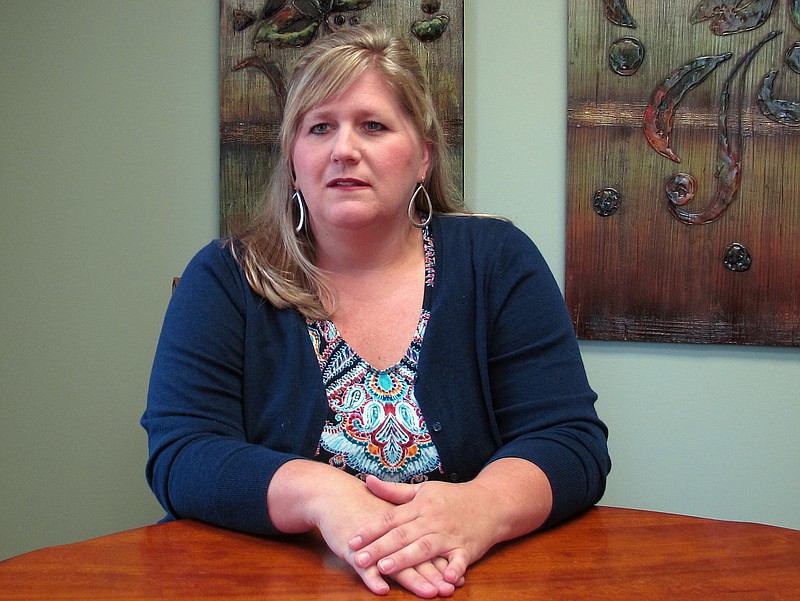 Staci Jones poses for a photo at her lawyer's office on Friday, June 22, 2018 in Collierville, Tenn. Advocates for domestic violence victims are praising a new Tennessee law that seeks to stop a common tactic that batterers use after their victims have fled to safety: Filing frivolous lawsuits designed to bankrupt or inflict more harm on the people they already have abused. Jones, teaches English as a second language and said she probably owes more than $100,000 from ongoing legal battles with a man she hoped to never see again.(AP Photo/Adrian Sainz)