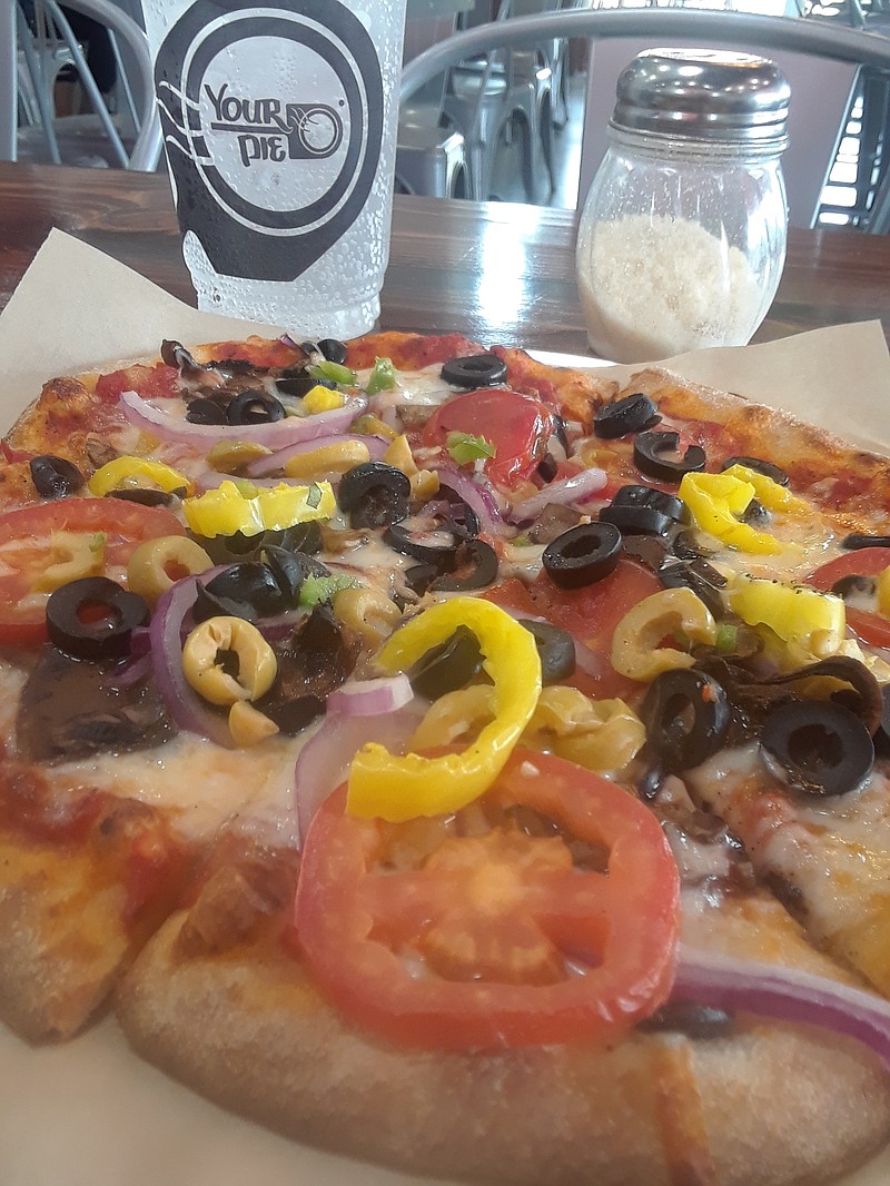 Wheat-crust pizza topped with marinara sauce, shredded mozzarella, mushrooms, tomatoes, green and black olives, green and banana peppers, jalapeno peppers and onions.