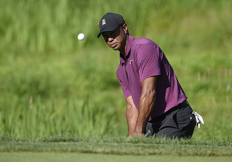 Tiger Woods hits out of a bunker on the 11th hole at TPC Potomac at Avenel during Friday's second round of the Quicken Loans National. Woods shot a 5-under 65 and was tied for 11th, four shots behind co-leaders Ryan Armour, Bryan Gay and Beau Hossler.