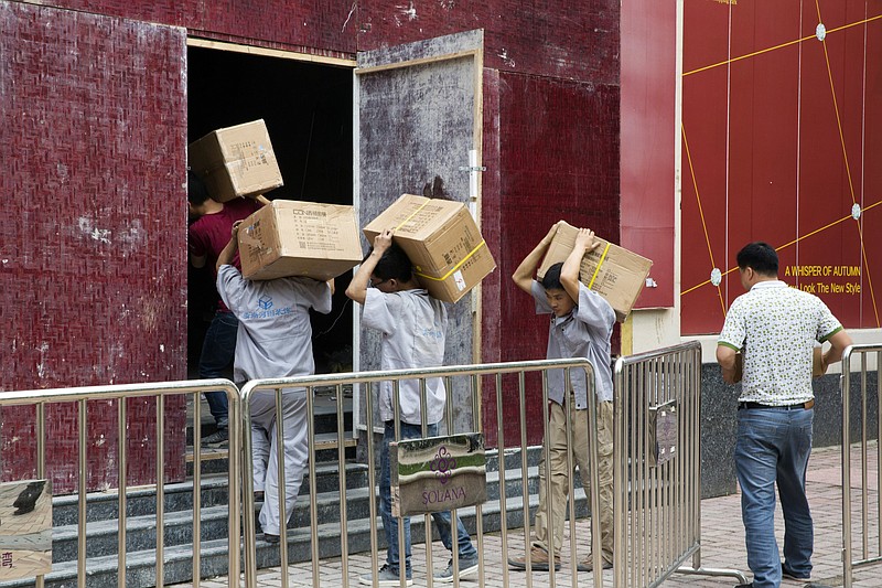 Workers carry boxes of LED lights into a renovation site in Beijing, China, Tuesday, July 3, 2018. Barring a last-minute breakthrough, the Trump administration on Friday will start imposing tariffs on $34 billion in Chinese imports. And China will promptly strike back with tariffs on an equal amount of U.S. exports. (AP Photo/Ng Han Guan)