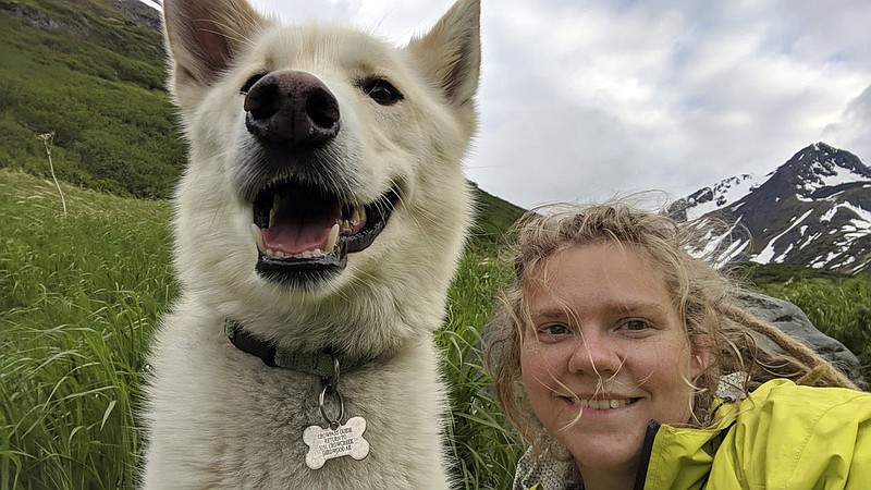 This Tuesday, June 19, 2018 photo by Amelia Milling shows her with a 7-year-old Alaskan husky named Nanook, that is credited with helping rescue her when she injured was hiking a trail in the Chugash State Park east of east of Anchorage, Alaska. 
