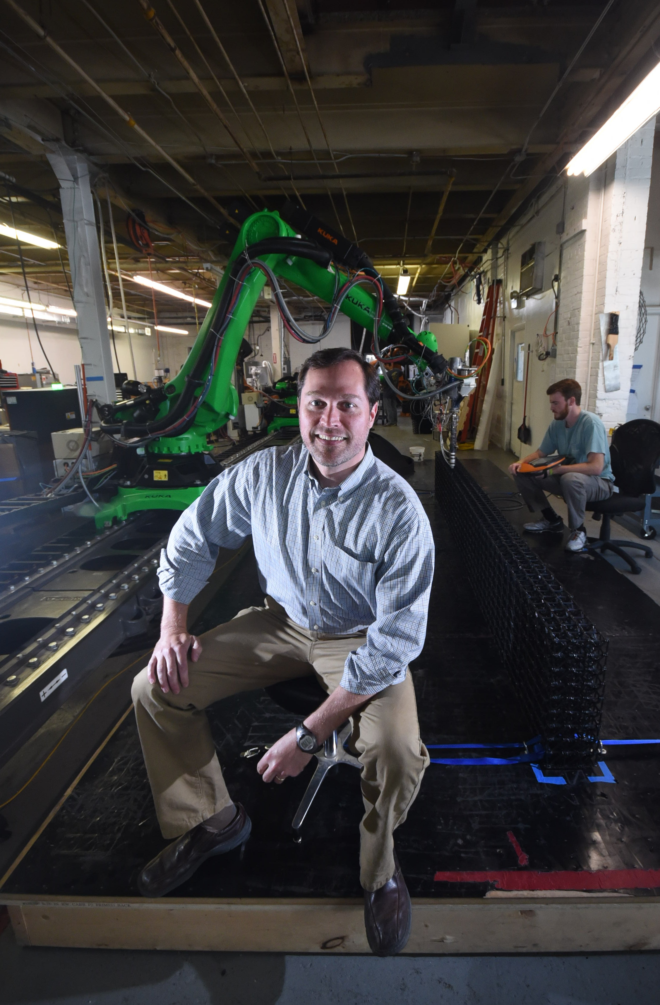 Branch Technology CEO Platt Boyd sits in front of the world's largest freeform 3D printer at the business inside the Chattanooga-Hamilton County INCubator on Cherokee Blvd. Robot operator David Goodloe, back right, is at the controls.