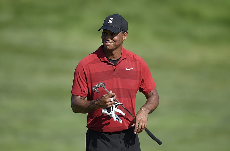 Tiger Woods smiles as he walks on the 16th fairway during the final round of the Quicken Loans National golf tournament, Sunday, July 1, 2018, in Potomac, Md. (AP Photo/Nick Wass)