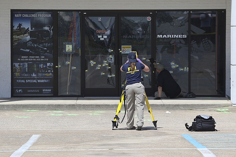 Federal Bureau of Investigation personnel document bullet holes at the Armed Forces Career Center off Lee Highway on Friday, July 17, 2015. A shooting spree that began there on Thursday, July 16 led to the deaths of four Marines and a Navy sailor.