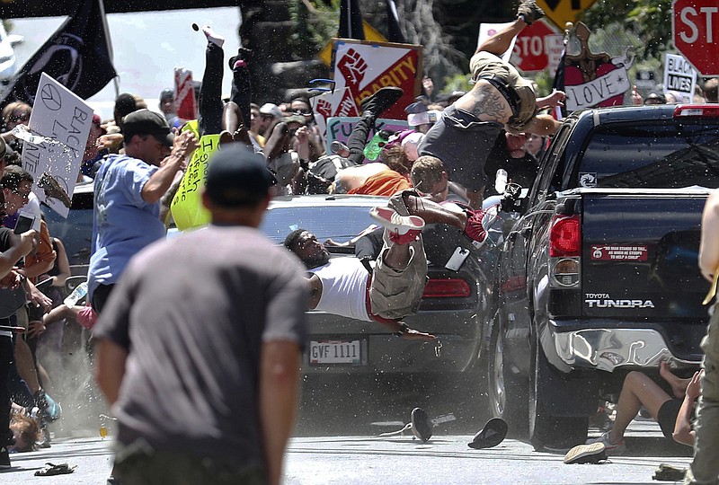 FILE - In this Aug. 12, 2017, file photo, people fly into the air as a vehicle is driven into a group of protesters demonstrating against a white nationalist rally in Charlottesville, Va. 