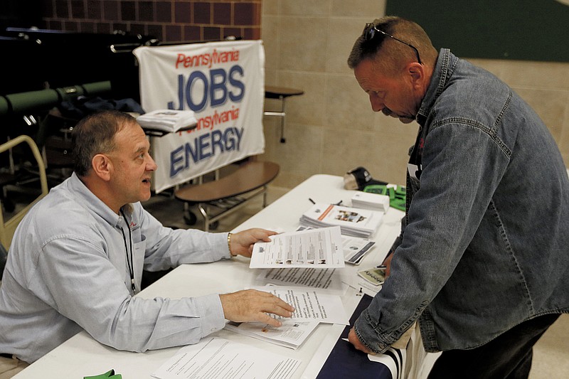 In this Thursday, Nov. 2, 2017, photo, a recruiter in the shale gas industry, left, speaks with an attendee of a job fair in Cheswick, Pa. Employers in the United States are thought to have kept up their brisk pace of hiring in June 2018, reflecting the durability of the second-longest U.S. economic expansion on record even in the face of a trade war with China. Economists have estimated that 195,000 jobs were added last month and that the unemployment rate remained at an 18-year low of 3.8 percent, according to data provider FactSet. (AP Photo/Keith Srakocic, File)