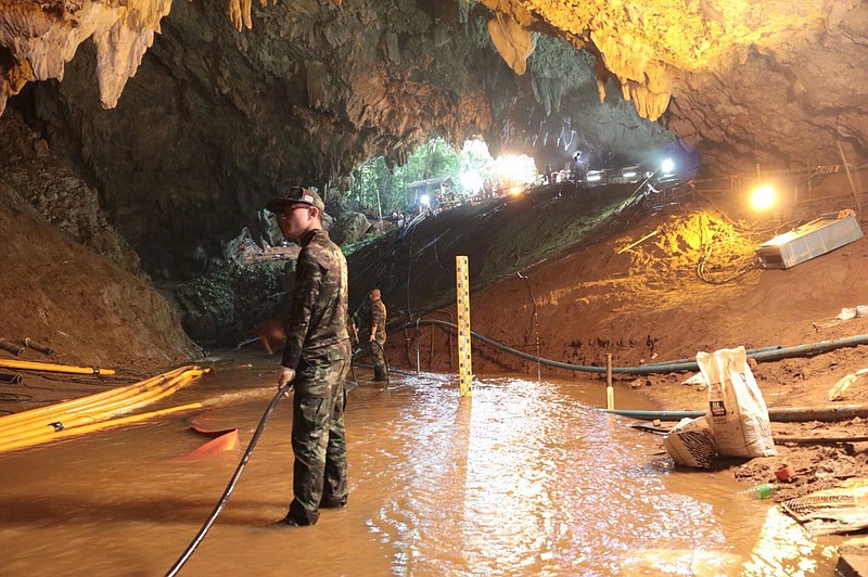 In this undated photo released by Royal Thai Navy on Saturday, July 7, 2018, Thai rescue teams arrange water pumping system at the entrance to a flooded cave complex where 12 boys and their soccer coach have been trapped since June 23, in Mae Sai, Chiang Rai province, northern Thailand. 