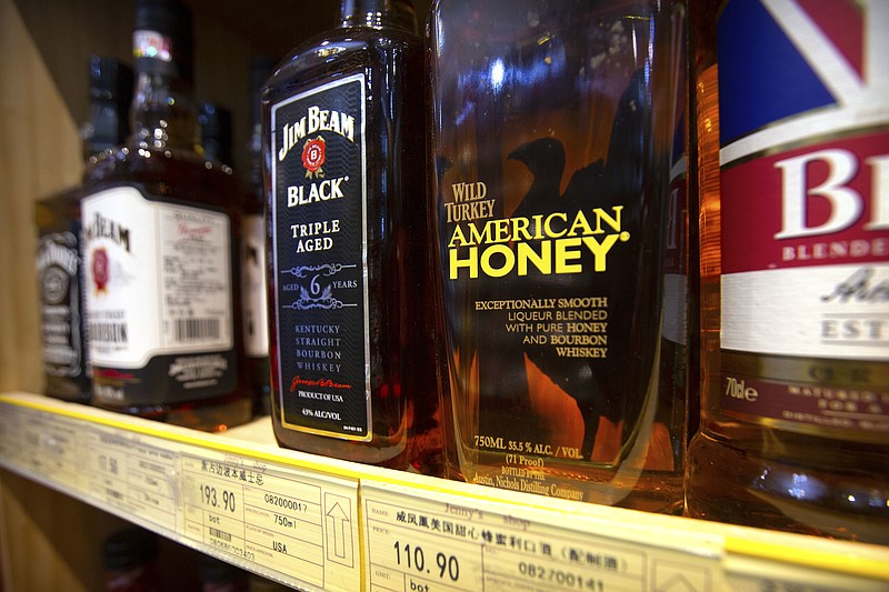 FILE - In this Saturday, July 7, 2018, file photo, whiskeys distilled and bottled in the U.S. are displayed for sale in a grocery store in Beijing. China’s options to retaliate in an escalating trade dispute with Washington go beyond matching U.S. tariff hikes to targeting American companies and government debt. Its state-dominated economy gives regulators tools to hamper sales of engineering, shipping and other services _ an area in which the United States runs a trade surplus _ and to disrupt operations for automakers, restaurant chains and other American businesses in China. (AP Photo/Mark Schiefelbein, File)