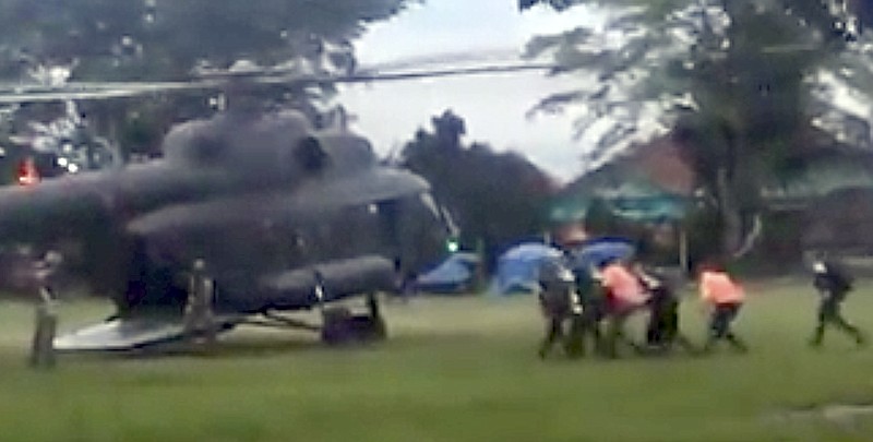 In this image made from video taken Sunday, July 8, 2018, an emergency team carries a stretcher believed to be carrying one of the rescued boys from the flooded cave to a waiting helicopter in Mae Sai, Chiang Mai province, northern Thailand. Thailand's interior minister says the same divers who took part in Sunday's rescue of four boys trapped in a flooded cave will also conduct the next operation as they know the cave conditions and what to do. (Big Krean via AP)