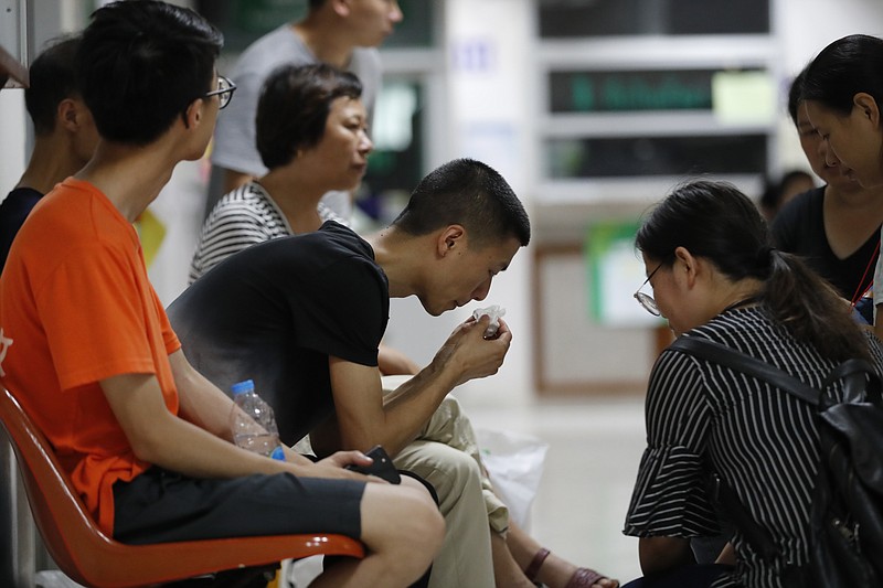 
              A Chinese relative of a victim in the recent boat sinking is consoled at the Vachira Phuket Hospital in Phuket, Thailand, Sunday, July 8, 2018. from Chalong pier in Phuket, Thailand, Sunday, July 8, 2018. Thai authorities have begun operations to salvage a tour boat that sank in a storm off the southern resort island of Phuket, killing 41 people, as they search for another 14 missing tourists. (AP Photo/Vincent Thian)
            