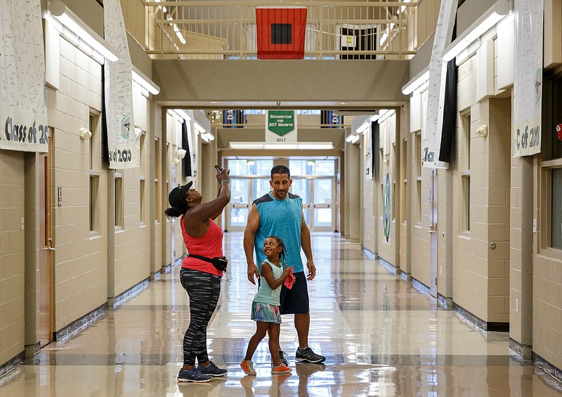 Tahnika Rodriguez, left, Armando Rodriguez, center, and their daughter Chloe arrive at East Hamilton Middle High School for a community meeting unveiling of plans for the new East Hamilton Middle School on Tuesday, July 10, 2018, in Chattanooga, Tenn. The new $36 million middle school will be built near Apison Elementary.