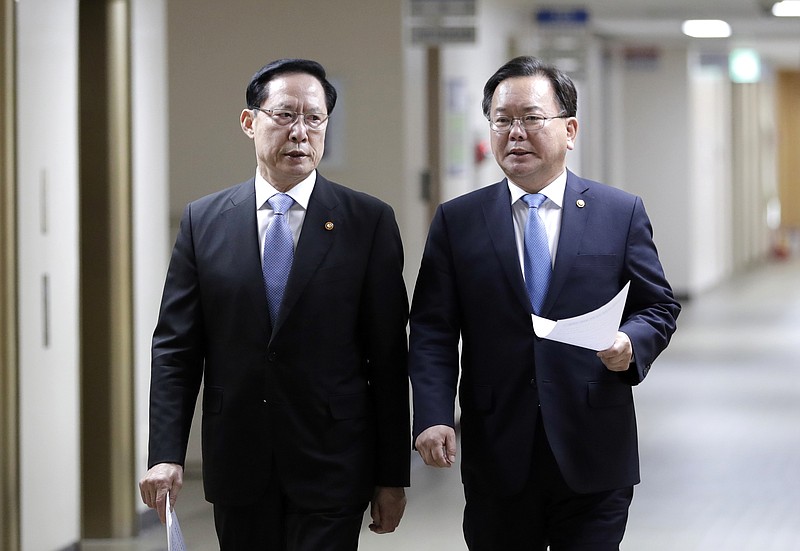 South Korea's Defense Minister Song Young-moo, left, and Interior and Safety Minister Kim Boo Kyum, right, arrive for a briefing at the government complex in Seoul, South Korea, Tuesday, July 10, 2018. 