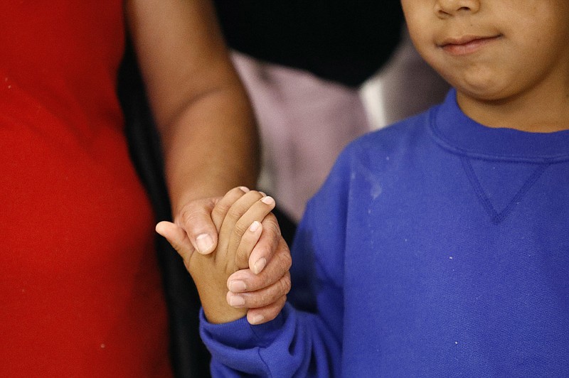 FILE - In this Friday, June 22, 2018, file photo, a mother, left, and son, from Guatemala, hold hands during a news conference following their reunion in Linthicum, Md., after being reunited following their separation at the U.S. border. 