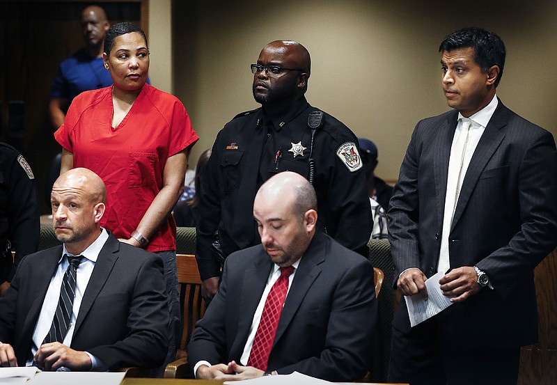 
              Sherra Wright, left, the ex-wife of slain former NBA player Lorenzen Wright, glances at her new court appointed attorneys Juni Ganguli, right, after her lawyers Steve Farese Jr. and Blake Ballin asked to be withdrawn from representing her during an appearance in Judge Lee Coffee's courtroom Wednesday, July 11, 2018 in Memphis. Shelby County Criminal Court Judge Lee Coffee granted a motion from Farese Jr. and Ballin for their removal from the case of Wright. She is charged with murder in the July 2010 slaying of Lorenzen Wright.  (Mark Weber/The Commercial Appeal via AP)
            