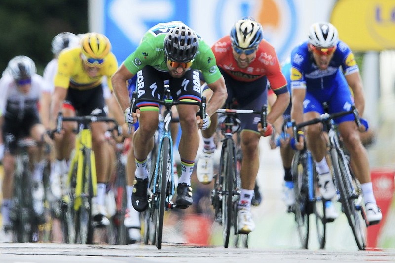 Slovakia's Peter Sagan, wearing the green jersey as the race's top sprinter, crosses the finish line first in the fifth stage of the Tour de France on Wednesday in Quimper. Behind Sagan are Greg Van Avermaet in yellow, Sonny Colbrelli in red and Phillippe Gilbert in blue.