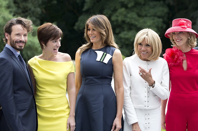 Amelie Derbaudrenghien, the partner of Belgian Prime Minister Charles Michel, second left, speaks with U.S. first lady Melania Trump, center, and French first lady Brigitte Macron, second right, during a group photo at the Queen Elisabeth Music Chapel in Waterloo, Belgium, during a spouses program on the sidelines of the NATO summit on Wednesday, July 11, 2018. (AP Photo/Virginia Mayo)