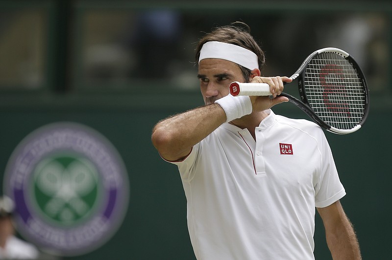 
              Roger Federer of Switzerland wipes his face during his men's singles match against France's Adrian Mannarino, on day seven of the Wimbledon Tennis Championships, in London, Monday July 9, 2018. (AP Photo/Tim Ireland)
            