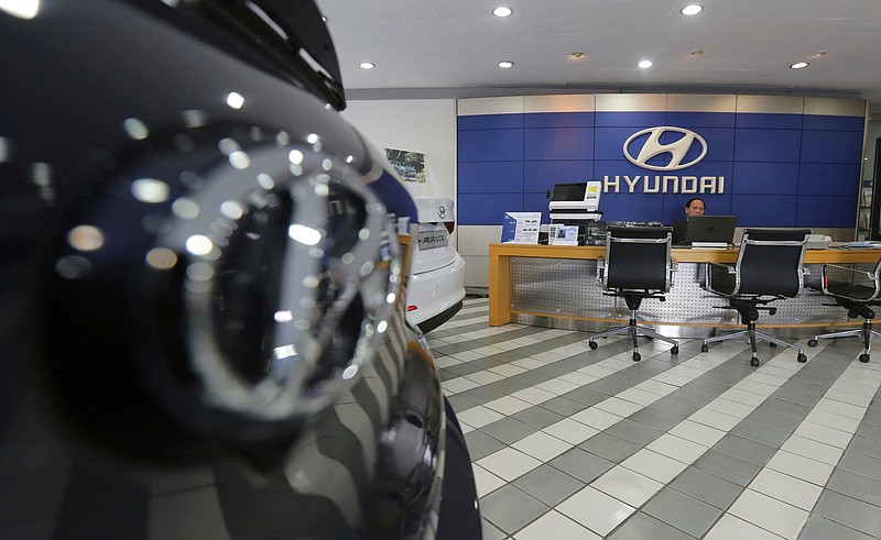 FILE - In this Jan. 25, 2018 file photo, an employee of Hyundai Motor Co. waits for customers at the company's showroom in Seoul, South Korea. Hyundai Motor Co.'s labor union said Thursday, July 12, 2018, steep auto tariffs that the U.S. is considering could cost tens of thousands of U.S. jobs. (AP Photo/Ahn Young-joon, File)