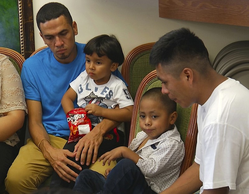 In this image taken from video, Javier Garrido Martinez, left and Alan Garcia, right, sit with their 4-year-sons at a news conference in New York, Wednesday, July 11, 2018.