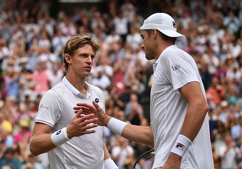 Kevin Anderson, left, meets John Isner at the net after defeating him in a marathon semifinal Friday at Wimbledon. Anderson won 7-6 (6), 6-7 (5), 6-7 (9), 6-4, 26-24 in a match that lasted 6 1/2 hours.