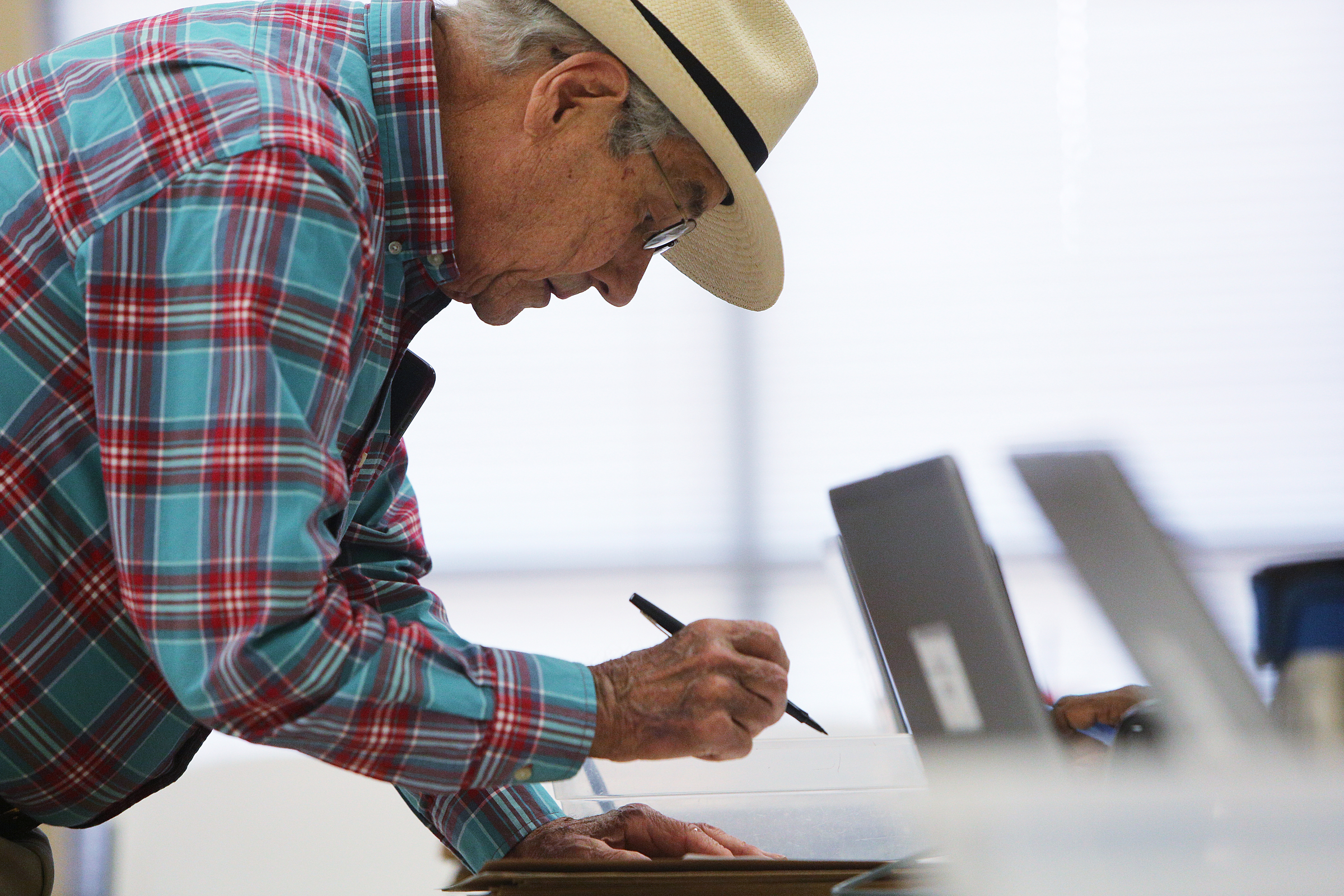 Bob Pickrell of Signal Mountain, Tennessee, signs paperwork before voting at the Hamilton County Election Commission Friday, July 13, 2018 in Chattanooga, Tennessee. By 3:40 p.m. Friday, 1,253 people had voted countywide.