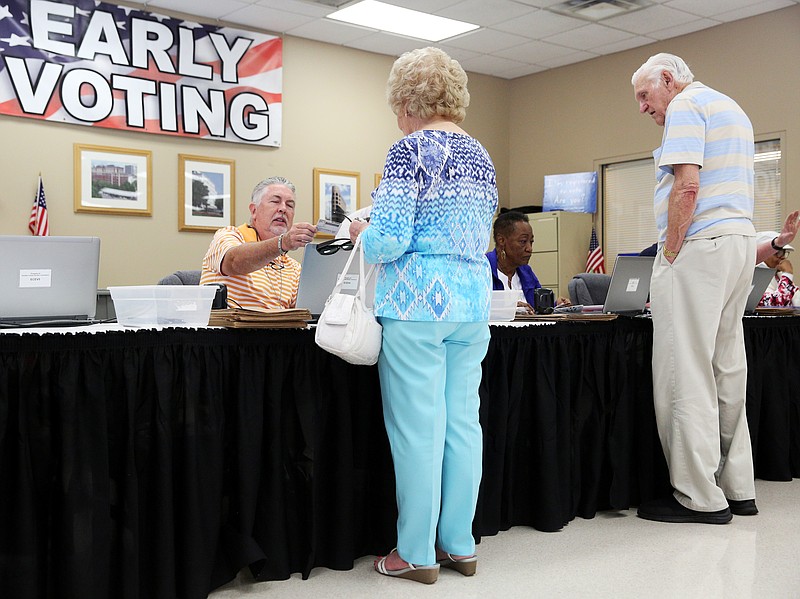 Jamie Hightower and Carolyn Tatum, election officials, help LaVerne and Ben Bonine of Lookout Valley, Tennessee, get their ballots to vote during early voting at the Hamilton County Election Commission Friday, July 13, 2018 in Chattanooga, Tennessee. While LaVerne was stating that they tend to participate in early voting to avoid the election day crowds, Ben jokingly chimed in with, "we might be in heaven before the real thing."