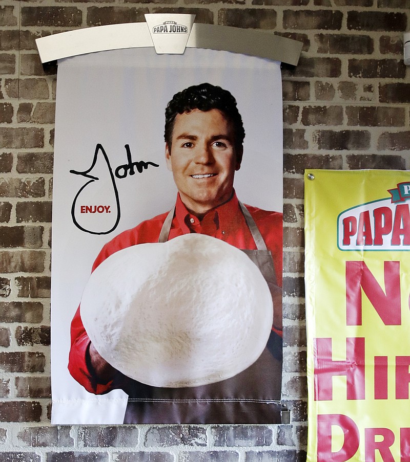 In this Dec. 21, 2017, file photo shows signs, including one featuring Papa John's founder John Schnatter, at a Papa John's pizza store in Quincy, Mass. Papa John's plans to pull Schnatter's image from marketing materials after reports he used a racial slur. Schnatter apologized Wednesday, July 11, 2018, and said he would resign as chairman after Forbes reported that he used the slur during a media training session. Schnatter had stepped down as CEO last year after criticizing NFL protests. (AP Photo/Charles Krupa, File)