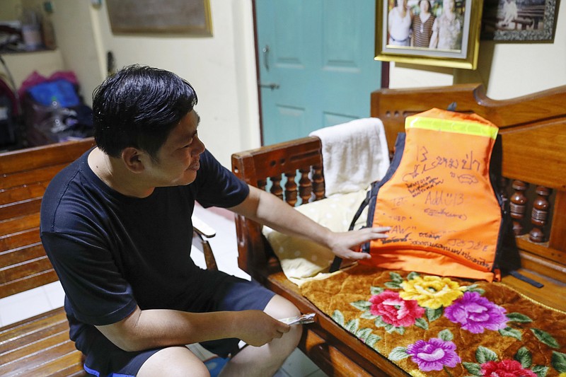 Banphot Konkum, father of Duangpetch Promthep, one of the rescued Thai boys, shows his son's life vest during an interview at their home in Mae Sai district, Chiang Rai province, northern Thailand, Friday, July 13, 2018. Banphot told The Associated Press his son, better known by his nickname, Dom, said that after the team members began their casual trek into the cave on June 23, they had no idea it had begun raining outside. But the rain caused flooding in the cave, blocking them from exiting. (AP Photo/Vincent Thian)

