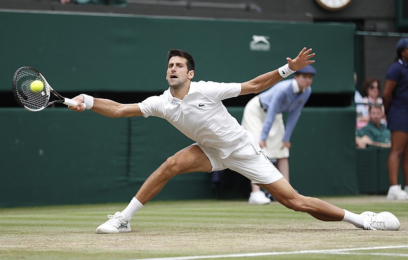 Novak Djokovic lunges to return a shot to Rafael Nadal during their Wimbledon semifinal Saturday in London. Djokovic won 6-4, 3-6, 7-6 (9), 3-6, 10-8, completing a match that started Friday but was suspended after the third set.