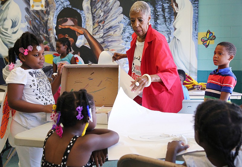 Joyce Fletcher hands out supplies to kids at the Avondale Youth and Family Development Center Friday, July 13, 2018 in Chattanooga, Tennessee. Chattanooga has expanded its Foster Grandparent program into the City's YFD Centers through a summer reading program. 