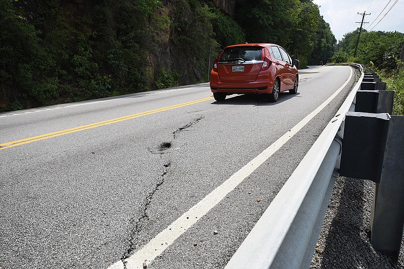 A long crack in the asphalt is visible as southbound traffic passes on high above the Tennessee River on Signal Mountain Road on Monday. Efforts are being made to get more repair done to the busy mountain access road.
