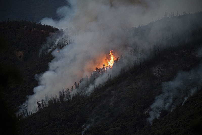 Flames from the Ferguson Fire burn down a hillside in unincorporated Mariposa County Calif., near Yosemite National Park on Sunday, July 15, 2018. (AP Photo/Noah Berger)