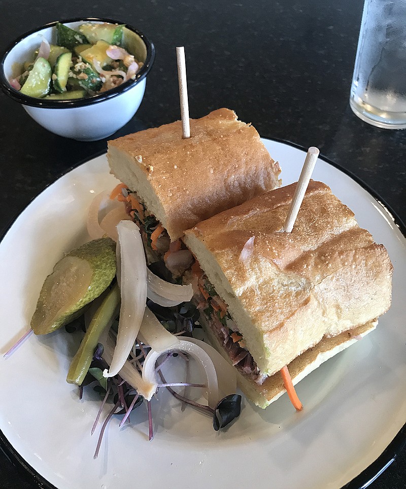 The Pork Belly Banh Mi at Kenny's Southside Sandwiches in the old Porker's BBQ location on Market Street features duck rillettes, carrots, radishes and cilantro on a baguette. It comes with a side of pickles, onions and edible flowers.