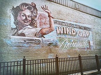 Contributed Photo by Christopher Deraney / Barnesville, Ga., artist Andrew Henry painted this Welcome to Wind Gap mural on the side of a building to be used in the filming of HBO's series "Sharp Objects." The mural will remain as a tourist attraction.