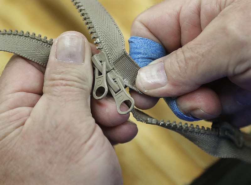 In this May 17, 2018 photo, two-way zippers are assembled at the Dunlap Industries facility in Dunlap, Tenn. The small zipper-making company is fighting to keep its pared-down staff occupied after it lost federal contracts to provide zippers for military uniforms. (AP Photo/Mark Humphrey)