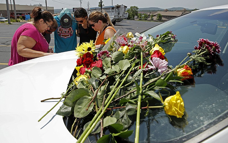 People pray next to a car believed to belong to a victim of a last night's duck boat accident, Friday, July 20, 2018 in Branson, Mo.